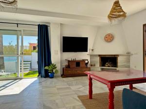 a living room with a tv and a fireplace at Casa Las Cumbres I - Ole Solutions in El Puerto de Santa María