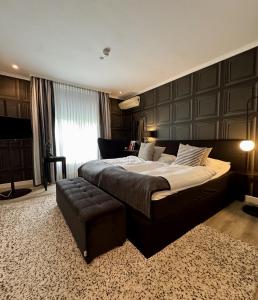 a large bedroom with a large bed and a stool at Parkhotel Bielefeld in Bielefeld