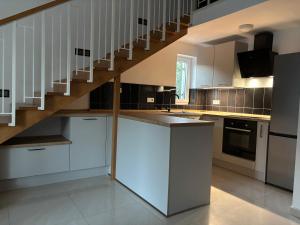 Una cocina con gabinetes blancos y una escalera. en Sea Garden House Mandre, en Mandre