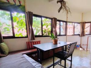 comedor con mesa y algunas ventanas en Hostel Swastik, en Bhaktapur