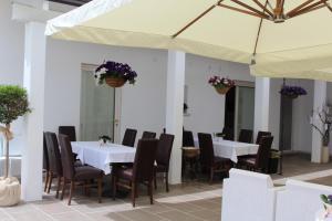a restaurant with white tables and chairs and a large umbrella at Villa Santoro in Ariano Irpino
