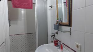 Un baño blanco con lavabo y espejo. en Ferienwohnung mit Meerblick, en El Guincho