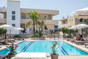 a swimming pool in front of a building at Vickys Rooms - Faliraki in Faliraki