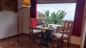 a table and chairs in a room with a window at Rustikale Ferienwohnung mit Balkon und Meerblick in Icod de los Vinos