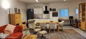 a living room with a table and a kitchen at Monteur-Ferienwohnung mit 123qm bei Würzburg mit Parkplatz Terasse Grill WLAN in Veitshöchheim