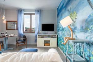 a bedroom with a blue wall with a bed and a tv at Draisina Bike Apartments UNO in Oleggio Castello