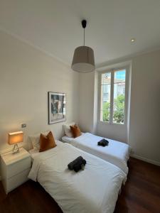 two beds sitting next to each other in a bedroom at AC-Free Parking - Contemporary 4 Bedroom Villa Apartment in Cannes