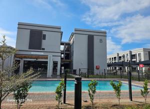 a building with a swimming pool in front of it at Schumie Apartments in Gaborone