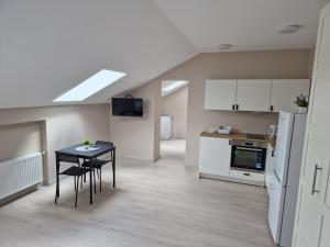 a kitchen and dining room with a table and a stove at FB Apartamentai in Plungė