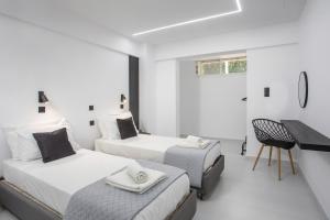 a white room with two beds and a desk at Vickys Rooms - Faliraki in Faliraki +37 photos