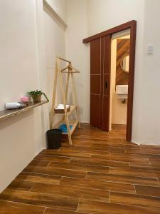 a hallway with a wooden floor and a wooden door at Khế Homestay in Can Tho