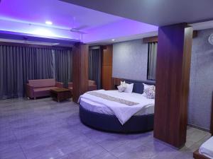 a bedroom with a large bed with a purple lighting at Hotel O Heritage Inn in Mehsāna