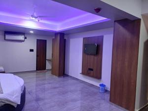 a bedroom with a bed and a flat screen tv at Hotel O Heritage Inn in Mehsāna