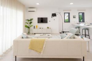 Una sala de estar blanca con un sofá y una mesa. en Paraiso da Foz - BY SCH, en Foz do Arelho