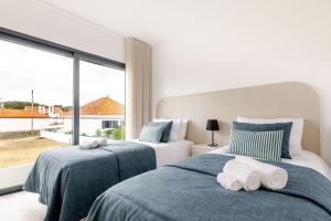 Dos camas en un dormitorio con una gran ventana. en Paraiso da Foz - BY SCH, en Foz do Arelho 27 fotos más