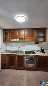 a kitchen with wooden cabinets and a stainless steel sink at Borgo di mare in Gaeta