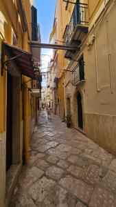 an alley with buildings and a person walking down the street at Borgo di mare in Gaeta