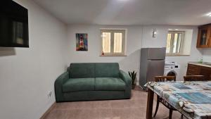 a living room with a green couch in a kitchen at Borgo di mare in Gaeta