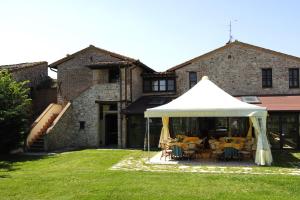a white tent in the yard of a house at Country House Podere Lacaioli in Castiglione del Lago
