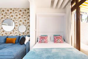 a bedroom with a bed and a blue couch at Virginia 555 Sol y Playa in Costa de Adeje +40 photos