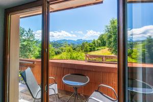 Un balcón con mesa y sillas y una vista en Home Tatra, en Biały Dunajec