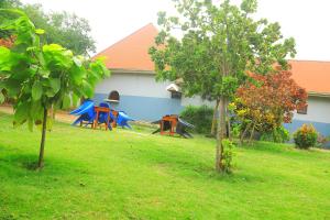 a yard with three picnic tables and a house at Green Pearl Adventures in Kikorongo