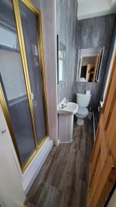 a bathroom with a toilet and a sink and a shower at Leecliff Guest House in Blackpool