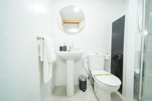 a bathroom with a toilet and a sink and a mirror at Apartamentos San Francisco con Terraza privada by Expoholidays in Almería +39 photos