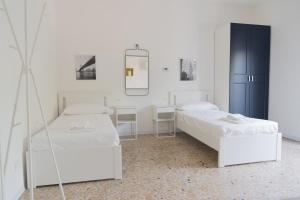 a white room with two beds and a mirror at Stadium Residence in Brescia