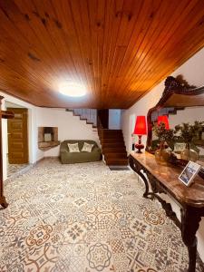 een woonkamer met een bank en een houten plafond bij Aroucanatur, Casa de Montanha in Arouca