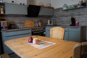 a kitchen with a wooden table and blue cabinets at Haus Quisisana - Fewo 1 - 4549 in Göhren
