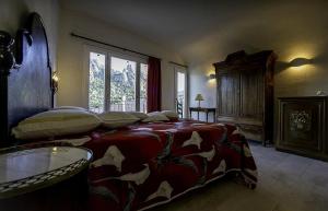 a bedroom with a bed and a table and a window at Antica Dimora La Corona in San Pantaleo +84 photos