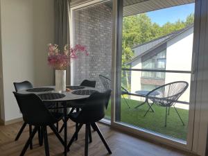 a dining room with a table and chairs and a window at MiMi Palanga - Self Check-in in Palanga