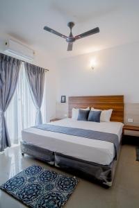 a bedroom with a large bed with a ceiling fan at Sea Breeze Goa in Talaulim +4 photos