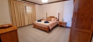 a bedroom with a bed and a table and a door at Villa Lucía in Tías +10 photos