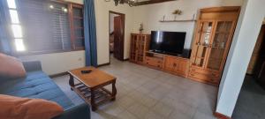 a living room with a couch and a tv at Villa Lucía in Tías