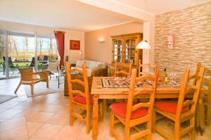 a dining room with a wooden table and chairs at Landhaus zum Strande - 44-07 in Kägsdorf