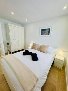 a bedroom with a large white bed with two pillows on it at Bungalow Mesana 27 in Playa Honda +12 photos