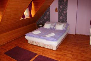 Un dormitorio con una cama con sábanas y almohadas púrpuras. en Szeibert Vendégház, en Balatonfüred