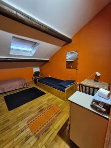a bedroom with orange walls and a bed and a desk at Appartamento completo o Camere private, Lecco Centro vicino alla stazione e al lago in Lecco