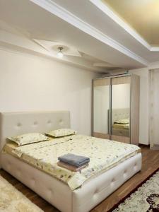 a bedroom with a large bed with a mirror at Микрорайон Джал in Bishkek