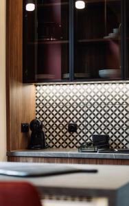 a kitchen with a black and white tiled wall at 1 - Lisa Moderna - DonViore in Győr