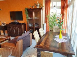 a living room with a wooden table and a couch at Dünenschloss - 02-27 in Kühlungsborn