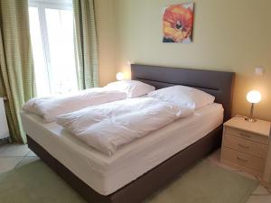 a bed with white sheets and pillows on it at Dünenschloss - 02-27 in Kühlungsborn +10 photos
