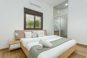 a bedroom with a large white bed with a window at Vista 2-Bedroom Apartment in Batroun 
