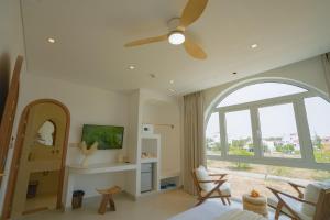 1 dormitorio con ventilador de techo y ventana grande en King Villa Hội an, en Thanh Ðông (1)