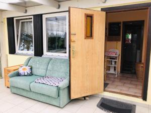 a couch sitting in front of a door at Gericke Bungalow GM 69303 in Graal +4 photos