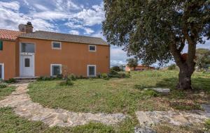 una casa con un árbol en el patio en Stunning Apartment In Veli Losinj With Wifi, en Veli Lošinj