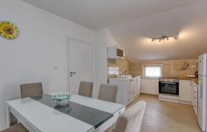 Una cocina con una mesa y sillas en una habitación. en Stunning Apartment In Veli Losinj With Wifi, en Veli Lošinj