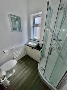 a bathroom with a shower and a toilet and a sink at 3-Bedroom House, with free parking in Luton